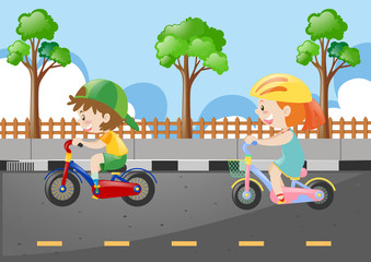 Two kids riding bicycle on the road