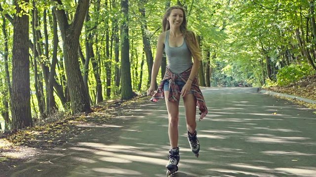 Young stylish woman skating on footpath.