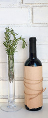 Concept of italian food and italian cuisine. Bottle of wine and rosemary against white brick wall.