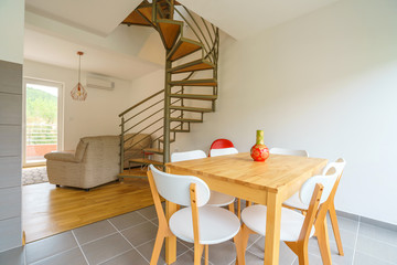 Interior of a guest house dining zone with spiral staircase