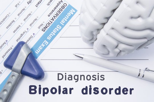 Diagnosis Bipolar Disorder. Medical psychiatrist opinion with written psychiatric diagnosis of bipolar disorder, questionnaire mental status exam, shape brain and neurological hammer is on table