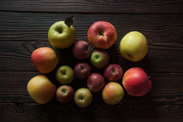 Group of apples different sizes on a wooden surface