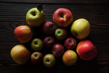 Group of apples different sizes on a wooden surface