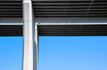 Obraz premium Underside of concrete bridge and pylon on sky.