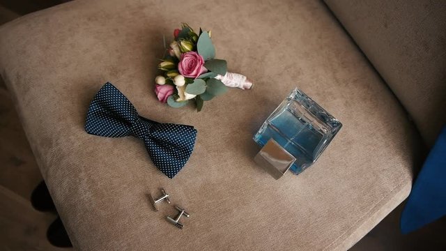 elegant men's accessory for wedding, toilet water with buttonhole lie on a chair, his jacket hanging on the back of a chair 5