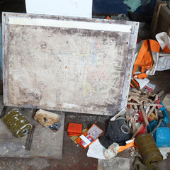 Old trash on floor of abandoned bomb shelter, gas mask, filters,aid kits and evacuation plan - decline of civil defense