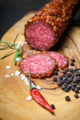 dried salami crusted in ground red pepper on dark background