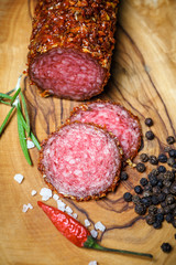 dried salami crusted in ground red pepper on dark background