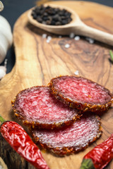 dried salami crusted in ground red pepper on dark background