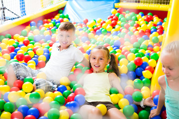 Fototapeta na wymiar kids playing with multicolored plastic balls .