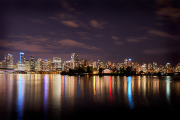 Fototapeta na wymiar Deadman's Island, Stanley Park, Vancouver. The Vancouver skyline reflects in Burrard Inlet at night. British Columbia, Canada.