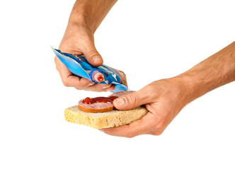 Hands put ketchup on the sandwich, isolated on white background