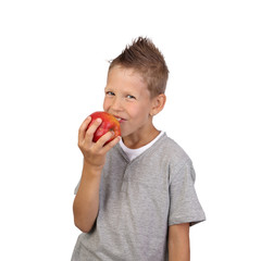 Joyful teenage boy eats big red apple in his hand isolated on white background is square