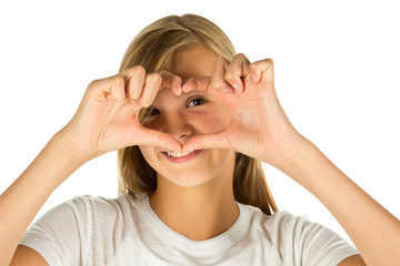 Young girl forming heart symbol with her hands over white background