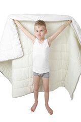 Cute little boy stands going to hide under blanket isolated on white background © jelenaaloskina