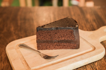Close up Slice of chocolate cake with frok on wood table.