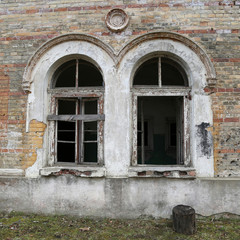 Ancient arched windows on old brick wall of abandoned building