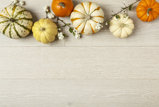 Miniature pumpkins on rustic wood background. Simple, natural country style fall autumn decorations.