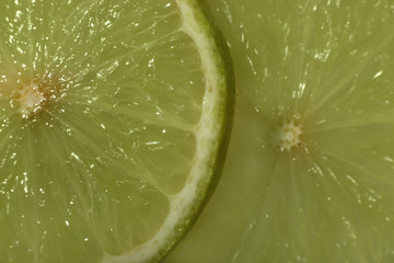 Lime slices juicy pale green pulp macro close up with edge and peel