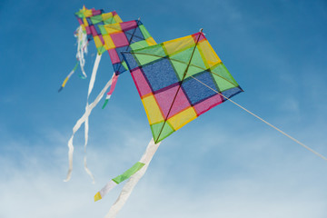 Colorful long line kites flying in blue sky