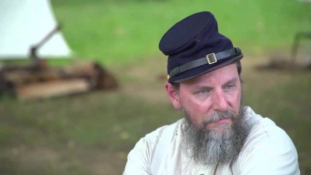 Civil War soldier sits near camp