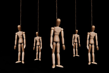 Low key, group of wooden marionettes puppet hangman by rope, on black background