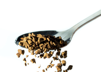 flavored instant coffee is poured into a mug with shiny spoons on white background
