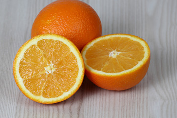 Whole and sliced fruits on table - cut in half orange pulp - diet, nutrition and natural vitamins concept
