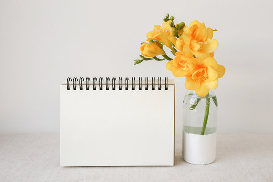 Notepad With Yellow Flowers In Vase Mock Up