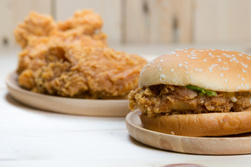 Sandwich with chicken burger on wooden plate.