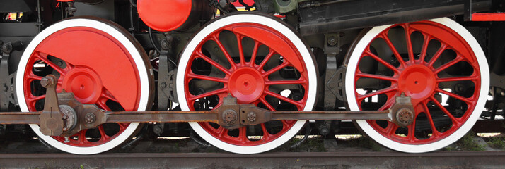 Three wheels of steam locomotive on rails closeup