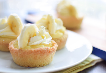 mini banana cream pies with whipped cream and sugar cookie crust