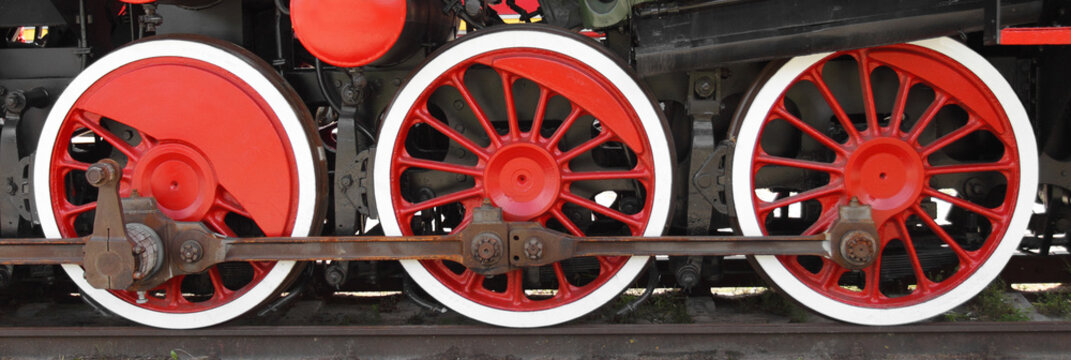 Three wheels of steam locomotive on rails closeup