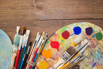 Fototapeta premium Paints, brushes and palette on the colorful background. The workplace of the artist. Banner for school