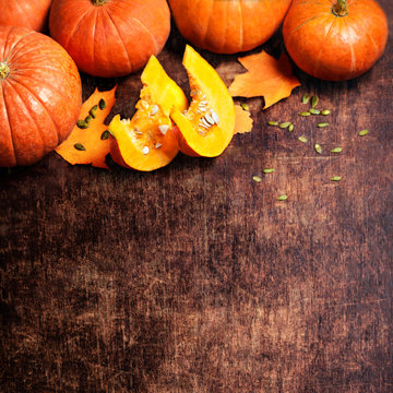 Autumn Pumpkin Thanksgiving Background - orange pumpkins over wooden table

