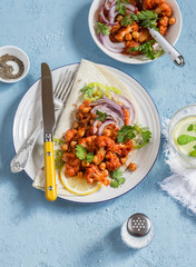 Spicy cauliflower in tomato sauce with chickpeas on flatbread. Tasty vegetarian food.