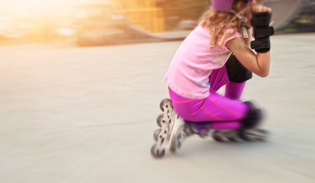young girl rides on rollers in skate park