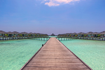 row of water bungalows on a tropical island - travel background