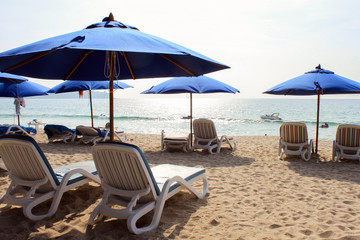 Fototapeta na wymiar blue sunbeds with umbrella near the sea