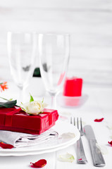 Elegant holiday table setting with red ribbon gift