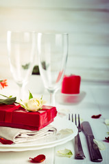 Elegant holiday table setting with red ribbon gift