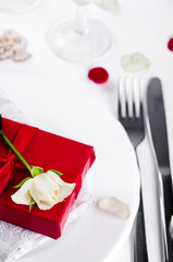 Elegant holiday table setting with red ribbon gift