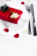 Elegant holiday table setting with red ribbon gift
