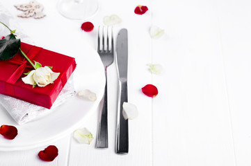 Fototapeta na wymiar Elegant holiday table setting with red ribbon gift