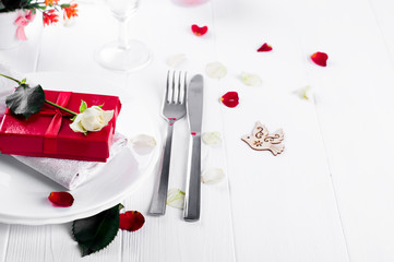 Elegant holiday table setting with red ribbon gift