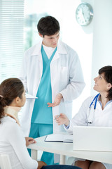 Doctor with nurse explaining something to patient in hospital