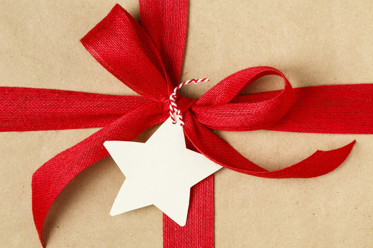 Christmas Gift With Bow And Blank Gift Tag. Simple Recycled Wrapping Paper And Natural Jute Ribbon.