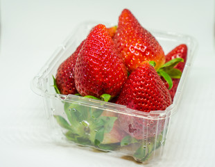 Group of fresh strawberries in plastics box, group of strawberries in white background