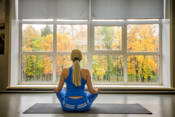 Shot of fitness woman sitting on exercise mat at fitness club.
