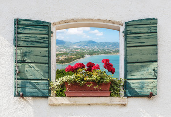 Sea view through the open window with flowers